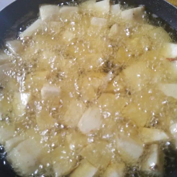 Kupas kentang dan potong dadu, lalu goreng dengan bawang putih.