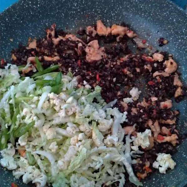 Masukkan nasi hitam kemudian sayuran, tambahkan kecap manis dan himsalt. Aduk-aduk sampai matang.