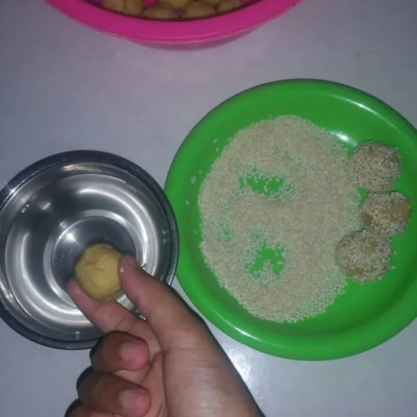 Celupkan adonan yang sudah di bentuk ke air lalu gulingkan ke wijen, lakukan sampai adonan habis.