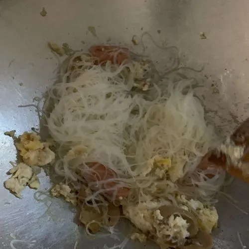 Masukkan bihun yang telah di rebus dan tiriskan. Aduk sampai rata dengan bumbu. Tambahkan garam dan lada.