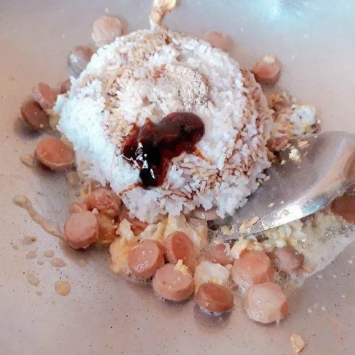 Masukkan nasi, kecap manis, saus tiram, garam, merica, dan kecap ikan, aduk rata.