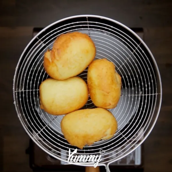 Letakan roti goreng dalam wadah, tambahkan gula salju. Kocok hingga gula merata.