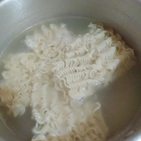 Rebus air hingga mendidih, kemudian masukkan mie instan. Rebus setengah matang saja.
