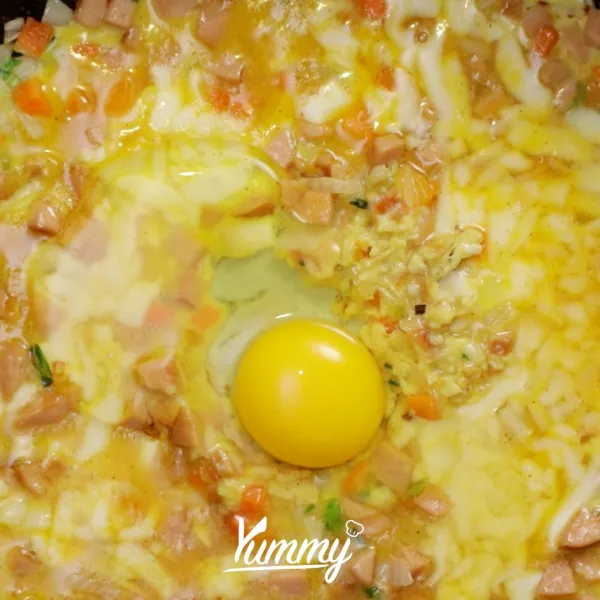 Pecahkan satu butir telur di atas lubang telur dadar, kemudian tutup teflon hingga tingkat kematangan yang diinginkan.