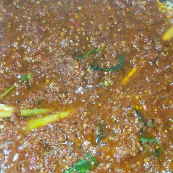 Haluskan bawang putih, bawang merah, cabai besar, dan cabai rawit dengan blender. Kemudian tumis bumbu yang telah dihaluskan itu bersama daun jeruk dan serai. Aduk terus agar bumbu tidak gosong.
