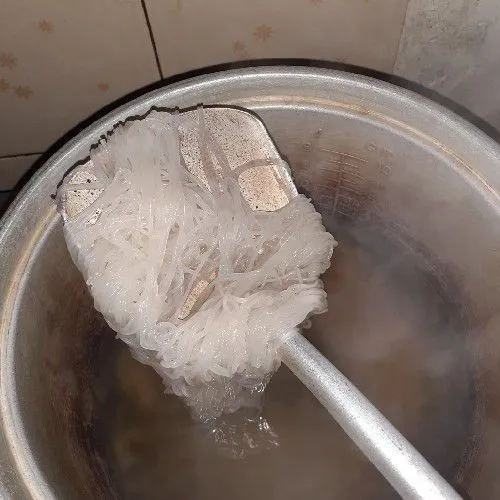 Rebus air, masukkan bihun sebentar, angkat dan tiriskan terlebih dahulu.