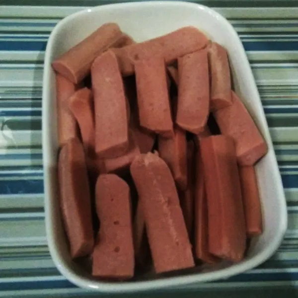 Potong sosis memanjang, kemudian belah menjadi 2, hingga dalam 1 batang sosia ada 4 bagian potongannya.