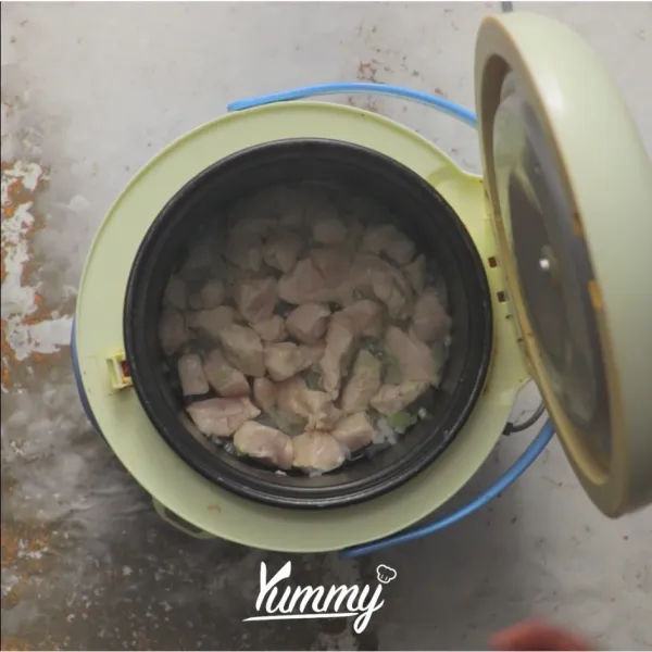 Panaskan minyak dalam rice cooker, tutup selama 2 menit. Panaskan bawang bombay hingga harum, masukkan ayam kemudian aduk merata. Tutup dan masak selama 5 menit.