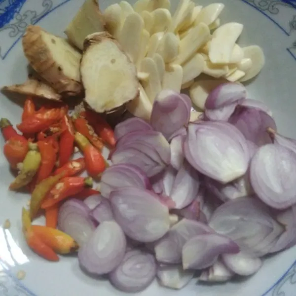 Iris-iris bawang merah, bawang putih, dan cabe rawit. Iris serong cabe besar taruh dalam wadah terpisah.