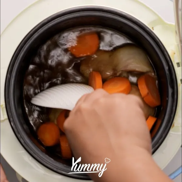Masukkan kaldu ayam dan wortel. Aduk rata. Masak selama 20 menit atau hingga air nya habis
