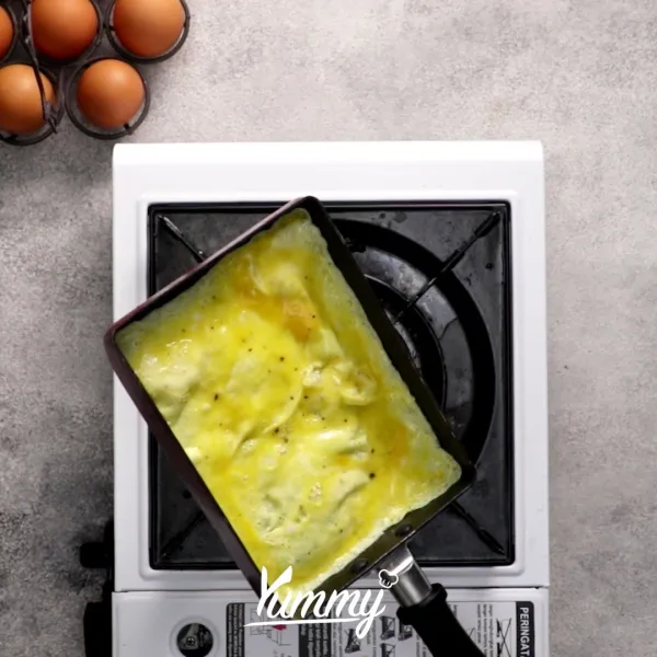Ambil 1 sendok sayur telur, lalu tuang ke dalam teflon telur panas. Setelah bagian atas mengering, sisihkan.