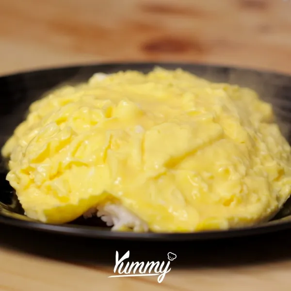Balik telur sebelum matang lalu sajikan di atas nasi putih.