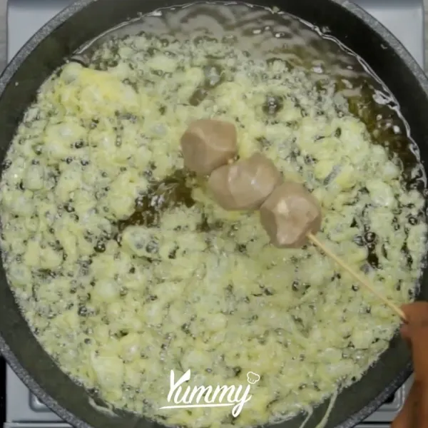 Panaskan minyak dalam teflon. Semprotkan telur ke minyak panas, setelah terlihat seperti jaring, gulung dengan tusukan bakso.