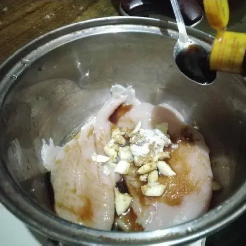 Bumbui fillet dada ayam dengan bawang putih, kecap asin, garam, dan kaldu jamur. Tambahkan sedikit air hingga ayam terendam. Diamkan kurang lebih 10 menit agar bumbu meresap ke dalam ayam.