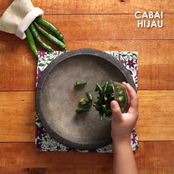 Masukkan potongan ayam, kemudian geprek satu persatu, selimuti ayam dengan sambal.