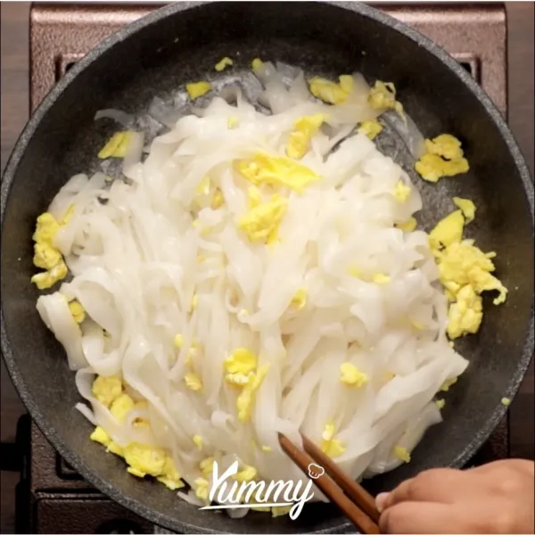 Panaskan minyak, lalu tuang telur yang sudak dikocok, lalu aduk aduk hingga pecah atau berbulir. Masukkan kwetiau rebus dan minyak ikan. Aduk rata, angkat tuang ke dalam mangkuk saji