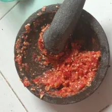 Haluskan bawang merah, bawang putih, cabai rawit, dan cabai keriting.