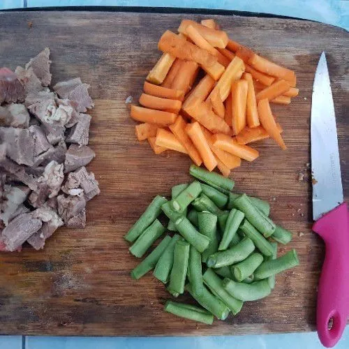 Potong dadu daging sapi rebus, potong memanjang wortel dan buncis.