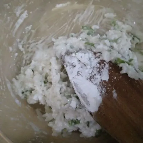 Siapkan nasi lalu masukkan 1 sdm sagu dan beri air panas. Lanjutkan masukkan 3 sdm sagu untuk diuleni. Masukkan potongan daun bawang dan aduk cepat.