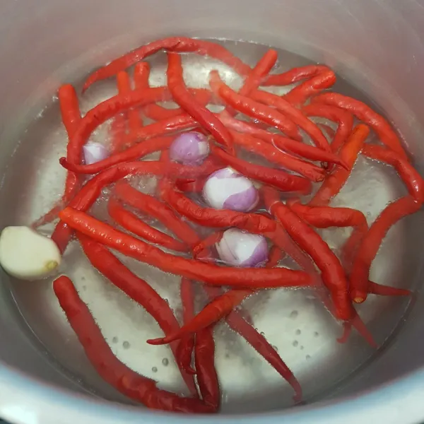 Rebus sebentar cabe merah, bawang putih dan bawang merah dalam air mendidih.