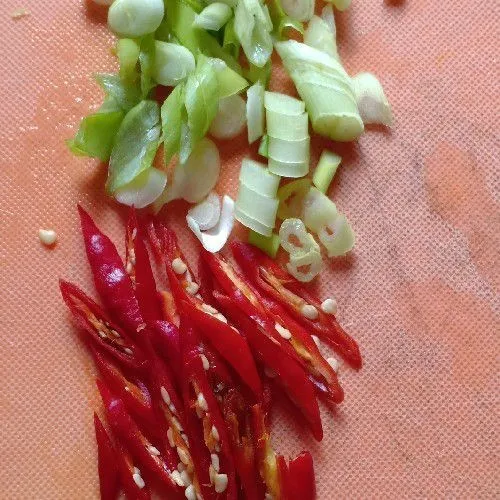 Iris serong daun bawang dan cabai merah, sisihkan.