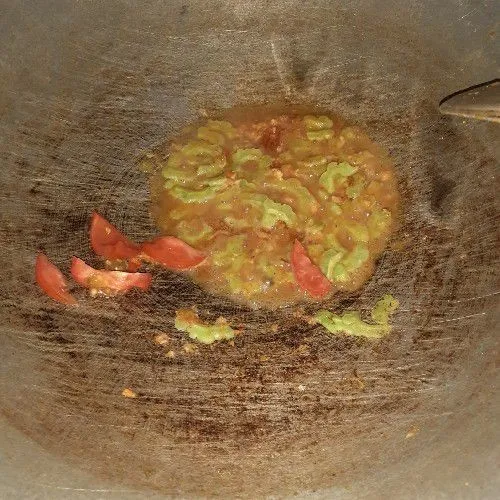 Tambahkan potongan tomat, air dan sedikit gula dan garam, aduk, tunggu hingga paria lembut.