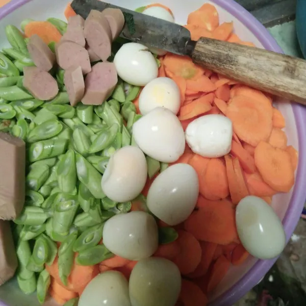 Potong kecil wortel, buncis, sosis dan kupas kulit telur puyuh yang sudah matang.