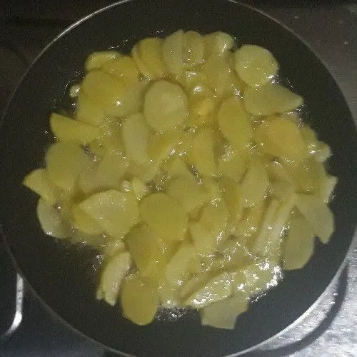 Kupas dan iris tipis kentang dengan ketebalan +- 3mm. Kupas dan iris tipis bawang bombay. Potong kecil-kecil cabe rawit. Potong daun seledri. Panaskan minyak, masukkan kentang dan masak sampai setengah matang.