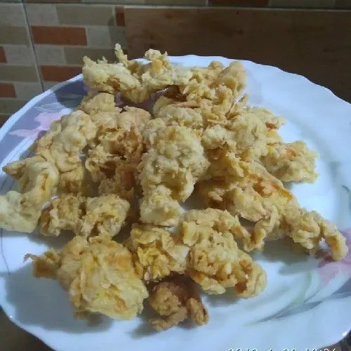 goreng ayam yang sudah dicampur dengan tepung sampai berwarna kuning kecoklatan