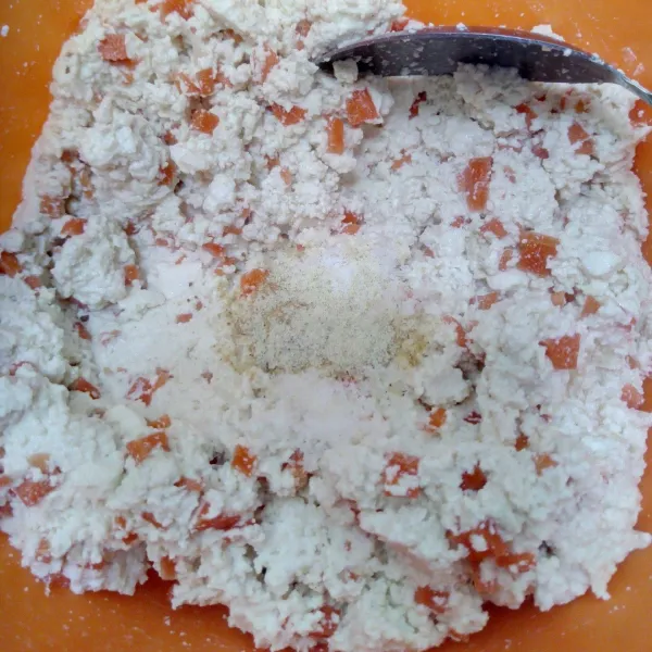 Campurkan bawang putih yang telah dihaluskan, merica bubuk, garam dan wortel yang telah diiris dadu ke dalam tahu yang telah halus, kemudian aduk rata.