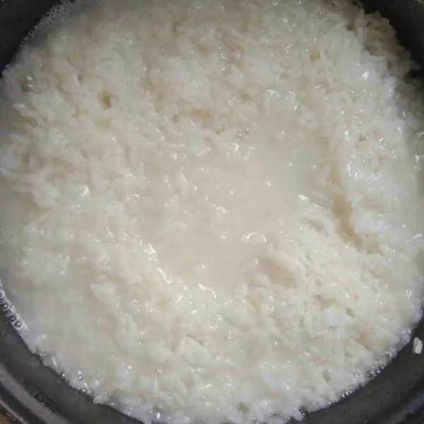 Cuci bersih beras, beri air dan masukkan masako ayam 3 bungkus. Aduk terus menerus, masak di rice cooker sampai matang.
