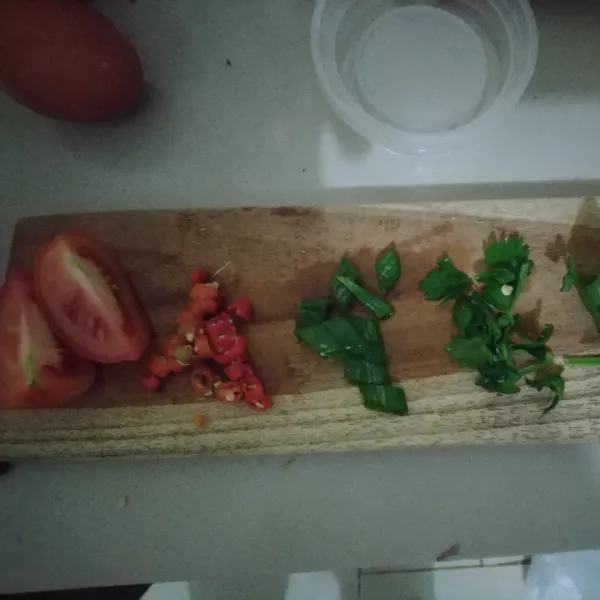 Iris cabe rawit, tomat, daun bawang dan seledri.