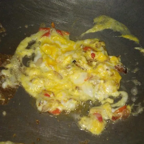 Setelah bawang mulai harum, masukkan cabai rawit dan telur sambil terus di aduk. Kemudian masukkan air.