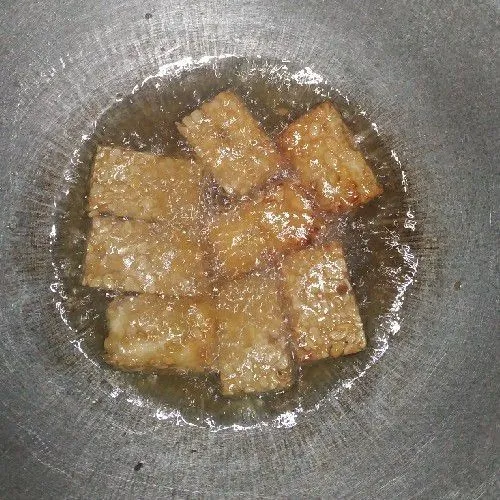Goreng tempe yang sebelumnya sudah di rendam air garam dan bawang putih halus, diamkan 3-5 menit hingga meresap, kemudian goreng dengan api sedang.