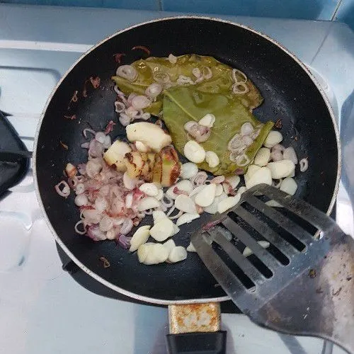 Tumis irisan bawang merah dan putih, lengkuas geprek, dan daun salam.