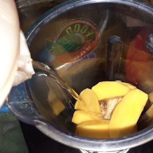 Campurkan potongan mangga dan pisang, beri sedikit air. Lalu haluskan dengan blender.