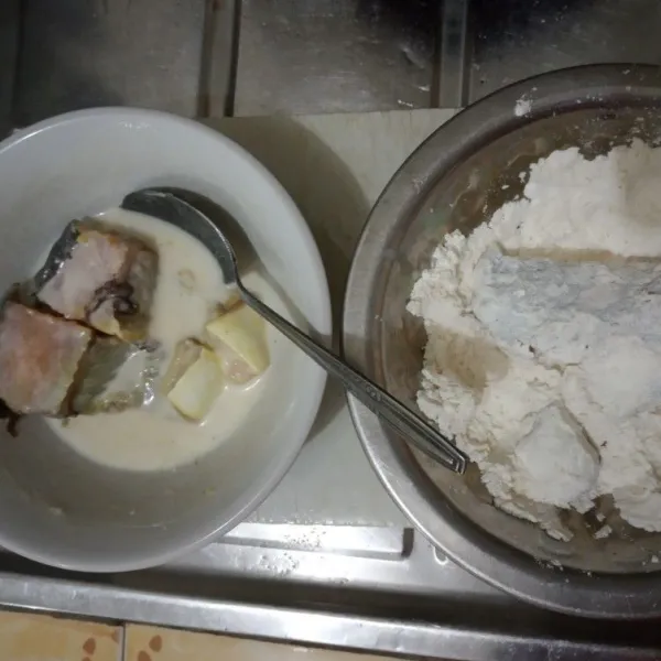 Celupkan ikan patin ke tepung yang basah, lalu balur ke tepung yang kering. Lakukan untuk semua ikan patin.