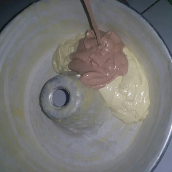 Olesi cetakan roti dengan mentega dan lapisi dengan terigu tipis-tipis. Tuang adonan secara bergantian pada satu titik yang sama.