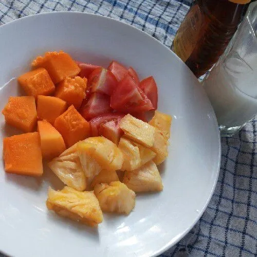 Potong daging buah nanas, pepaya, dan tomat.