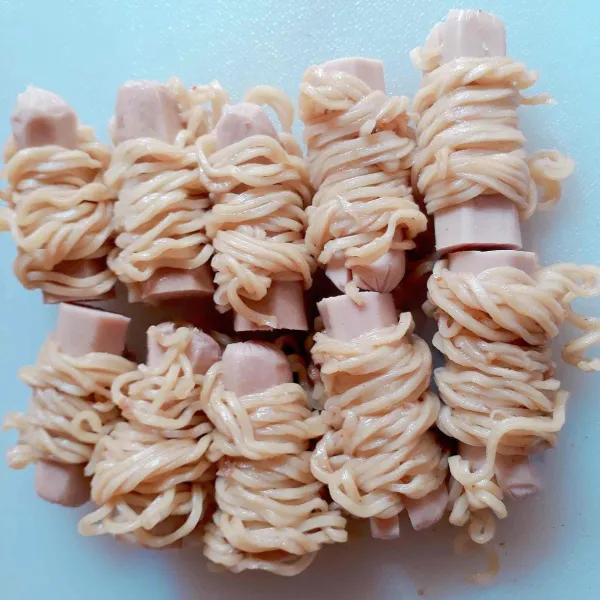 Gulung sosis dengan mie, ujung mie selipkan dikeratan sosis agar tidak lepas.
