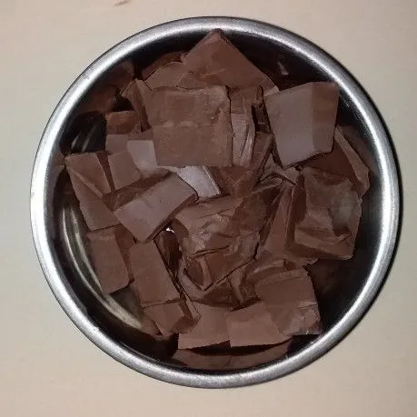 Sambil menunggu adonan es dingin, lelehkan coklat blok, cincang kasar coklat blok dan masukkan ke dalam mangkok tahan panas.