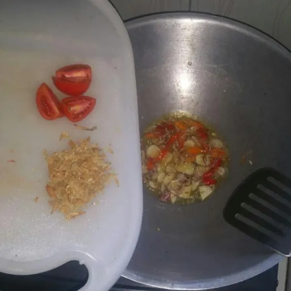 Panaskan minyak, tumis duo bawang sampai harum lalu masukkan cabe rawit aduk rata, disusul masukkan tomat dan ebi. Masak sampai tomat setengah layu.