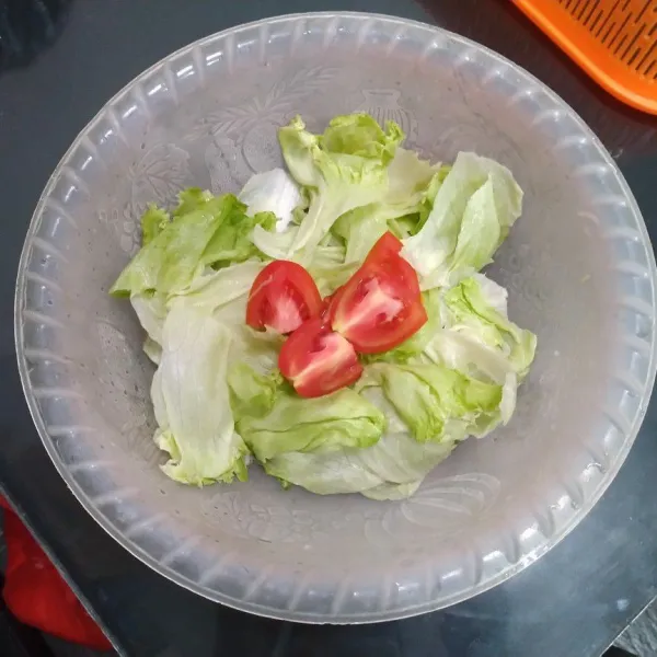 Cuci daun selada lalu sobek-sobek dan tomat dipotong jadi 4.
