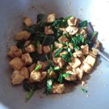 Setelah sawi mulai layu, masukkan tahu, aduk rata.