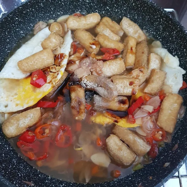 Kemudian masukkan telur dan tahu, tambahkan air / kaldu ayam, aduk rata. Tambahkan saus tiram, kecap manis, gula, garam dan kaldu jamur bubuk. Aduk rata dan masak hingga air sedikit menyusut.