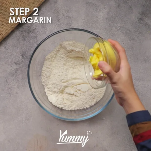 Masukkan margarin ke dalamnya, aduk hingga adonan berpasir.
