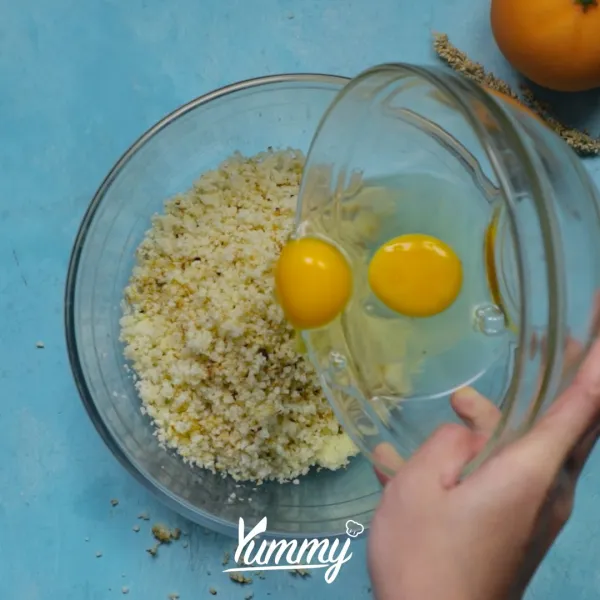 Campurkan kembang kol dengan telur, keju parmesan, bubuk bawang putih, keju mozarella, garam, dan oregano. Aduk rata.