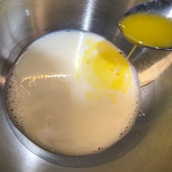 Tuang susu di dalam wadah, lalu tambahkan minyak/mentega cair.