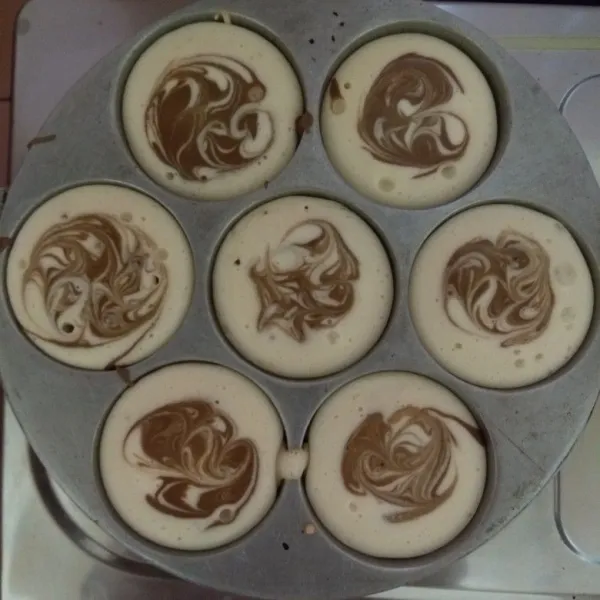 Panaskan cetakan, kemudian tuang satu sendok sayur adonan putih dan satu sendok teh adonan mocca diatasnya.