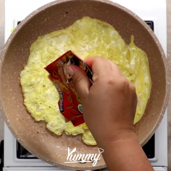 Segera masukan kornet, lalu bungkus kornet dengan telur. Kemudian balik dan masak hingga matang.